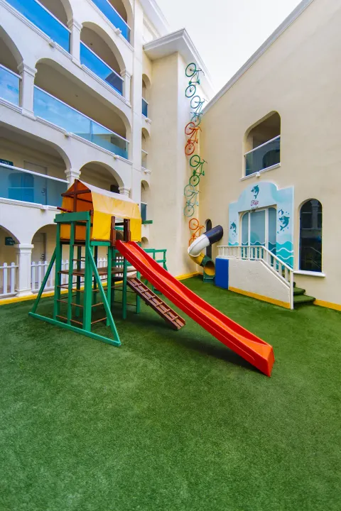 Outdoor children's play area with red slide at Occidental Costa Cancún.