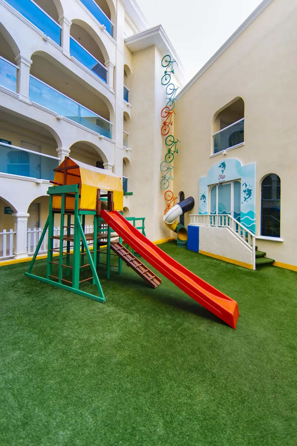 Outdoor children's play area with red slide at Occidental Costa Cancún.