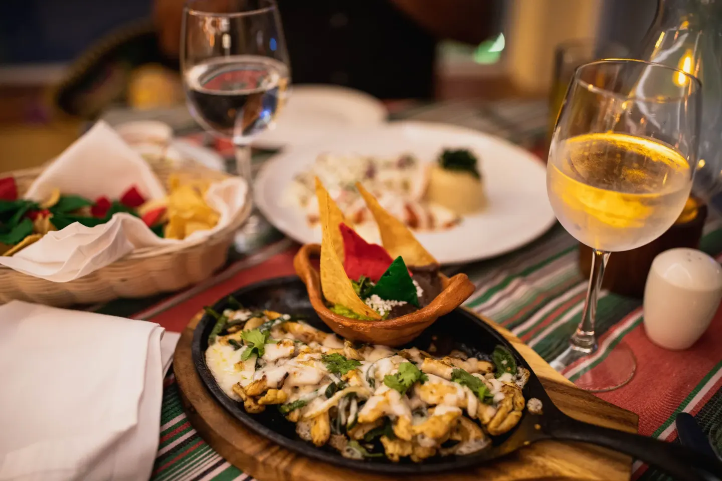 Mexican skillet dish with tortilla chips and wine at Occidental Costa Cancún.