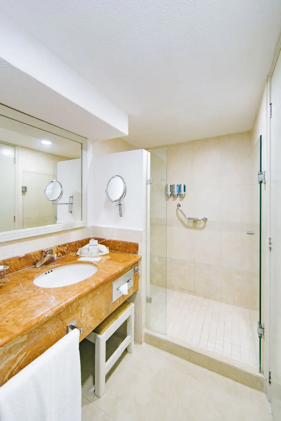 2x2 interconnecting room bathroom with vanity and glass shower at Occidental Costa Cancún.