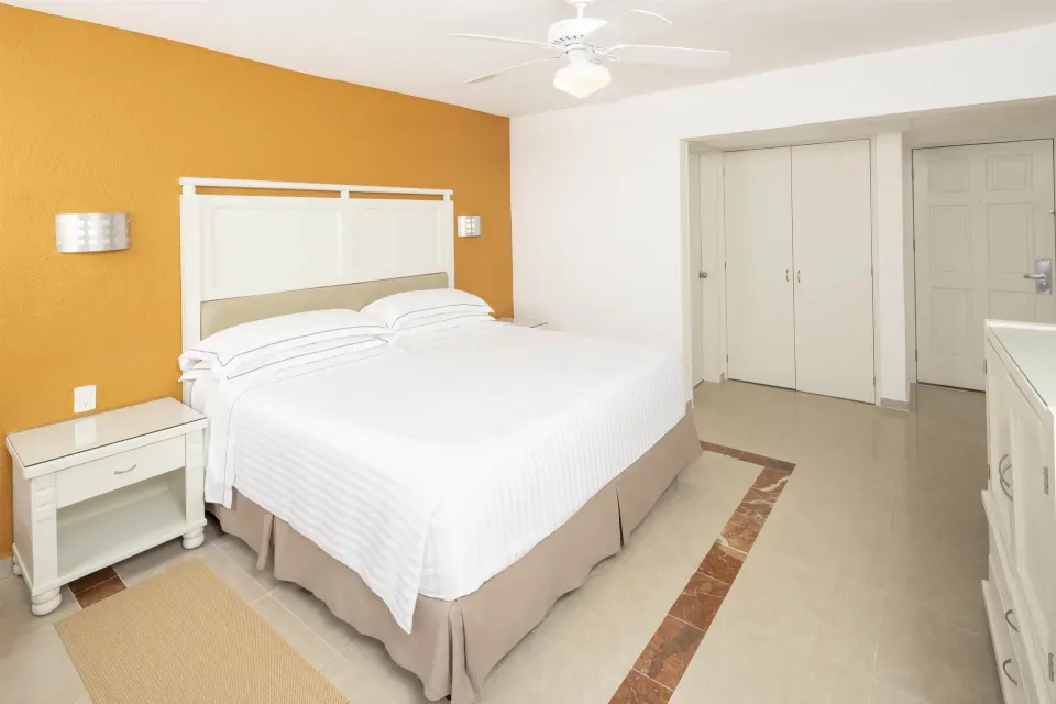 2x2 interconnecting room with king bed, closet, and dresser at Occidental Costa Cancún.