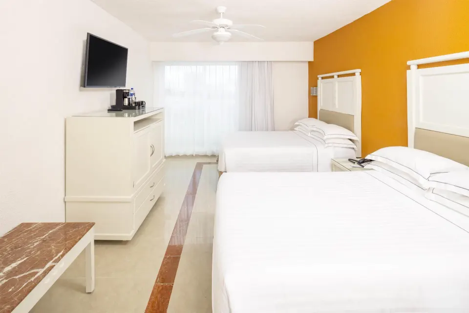 2x2 interconnecting room with two double beds and TV at Occidental Costa Cancún.