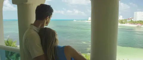 Guests on an Ocean View room balcony overlooking the sea at Occidental Costa Cancún.