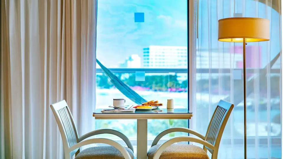 Ocean View room table by balcony doors with breakfast setting at Occidental Costa Cancún.