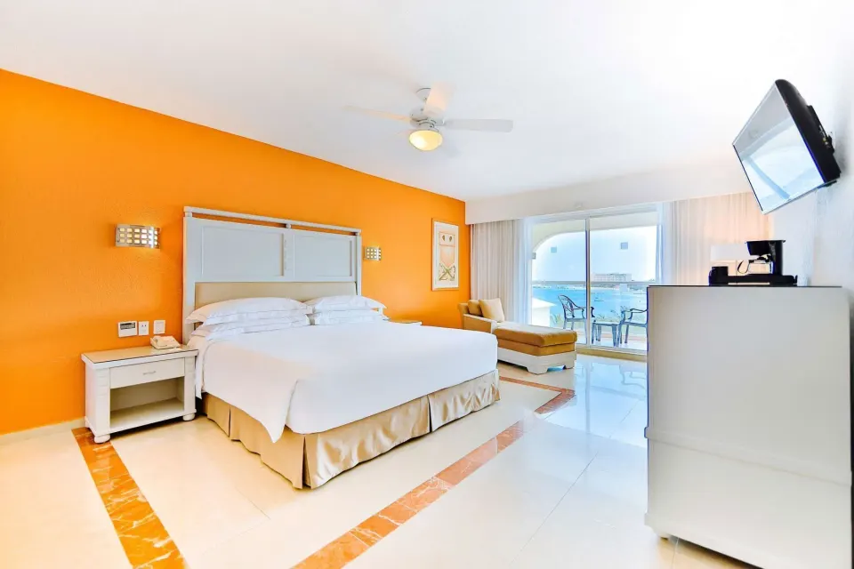 Ocean View room with king bed, sitting area, balcony, and sea view at Occidental Costa Cancún.