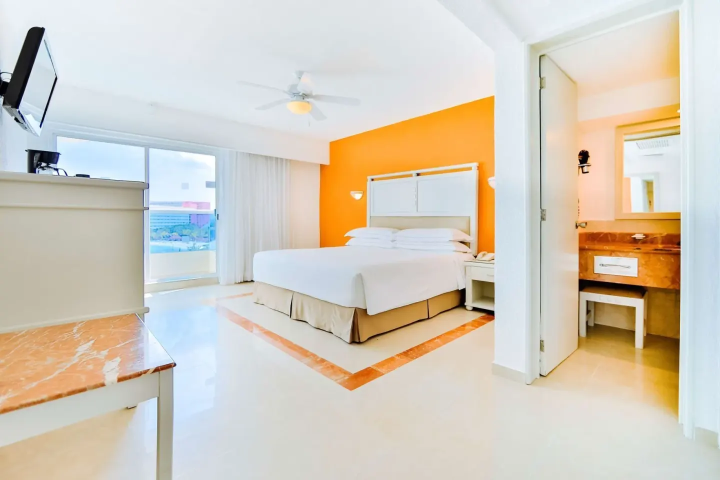 Ocean View room with king bed, balcony doors, and vanity area at Occidental Costa Cancún.