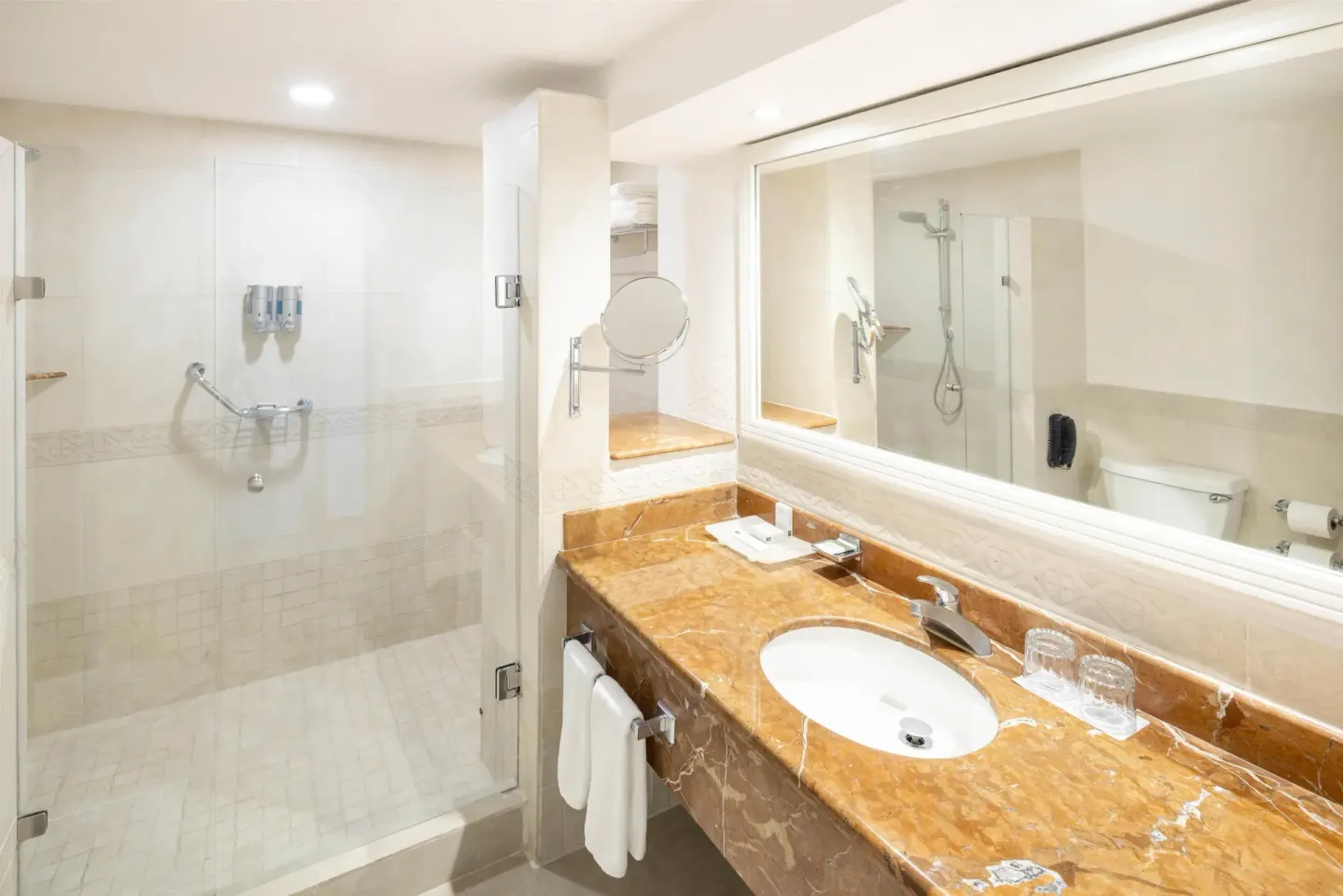 Sea View room bathroom with sink, mirror and glass shower at Occidental Costa Cancún.