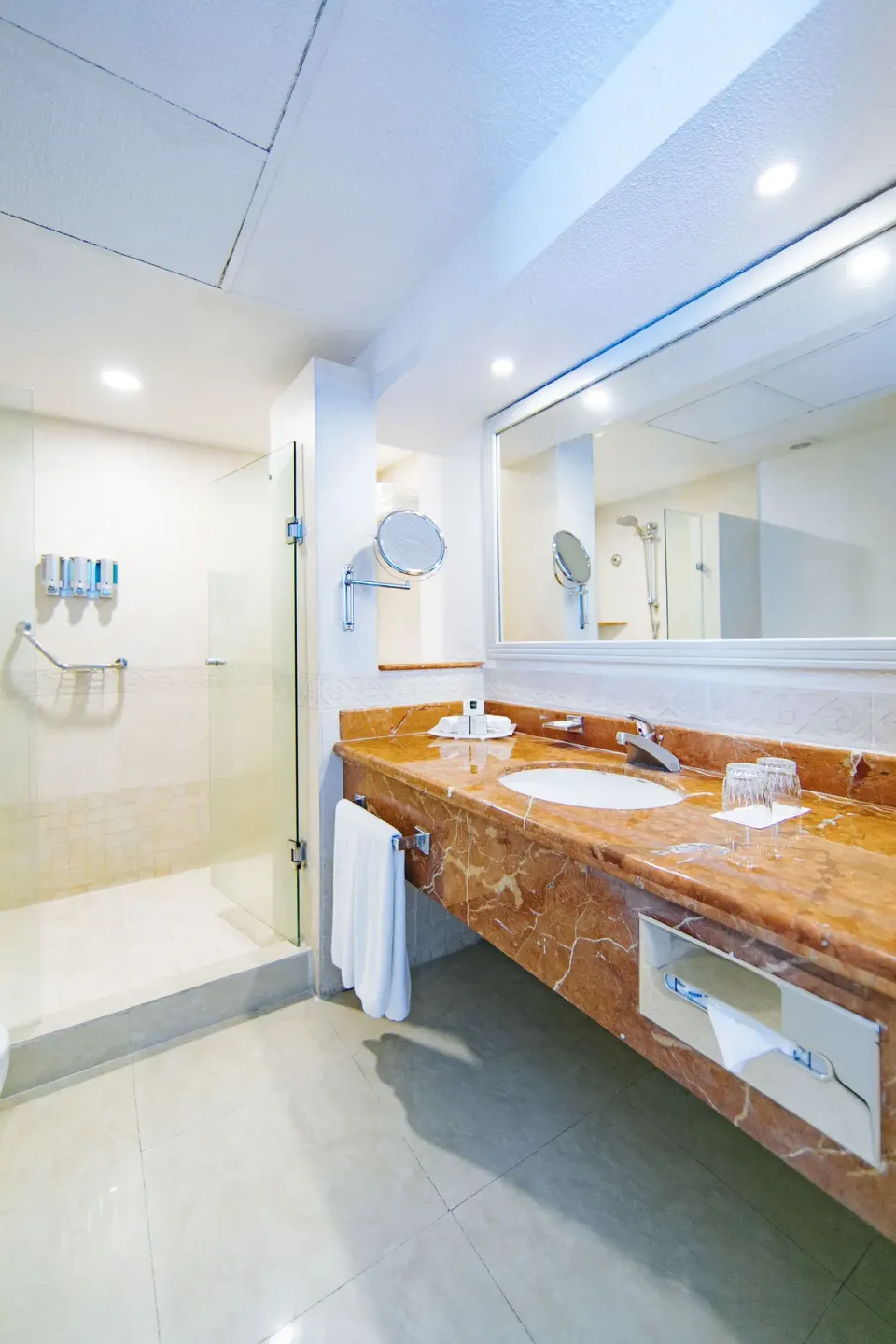 Sea View room bathroom with marble vanity and glass shower at Occidental Costa Cancún.