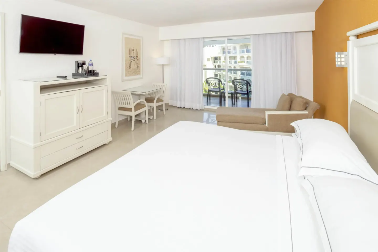Terrace guest room with king bed, TV, desk and balcony at Occidental Costa Cancún.