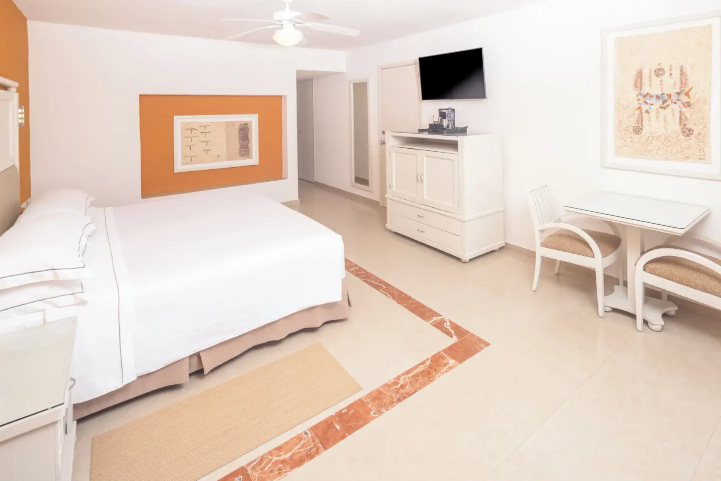Terrace guest room with king bed, TV cabinet and dining table at Occidental Costa Cancún.