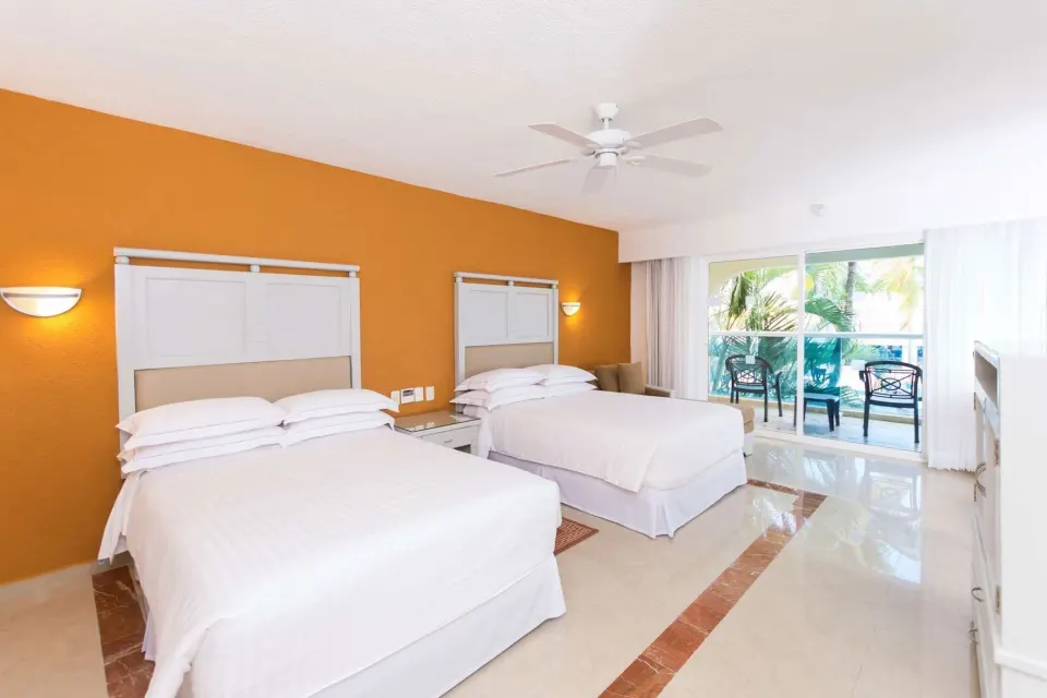 Room with Terrace at Occidental Costa Cancún with two beds and sliding glass doors to a balcony.