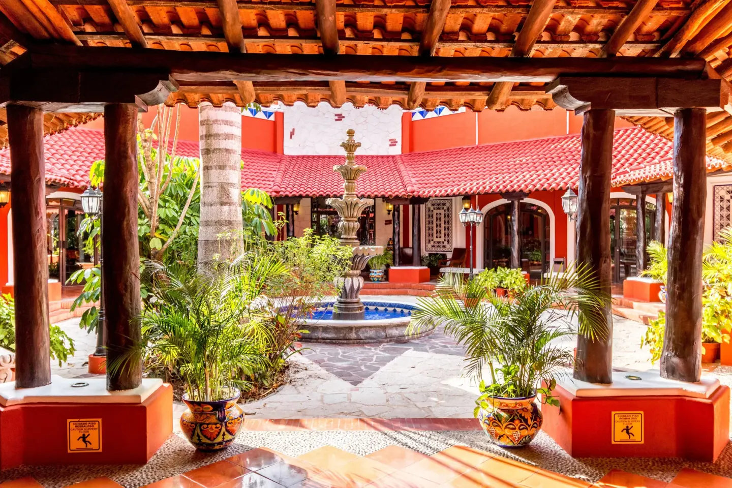 Courtyard fountain framed by columns and tropical plants at Occidental Cozumel.