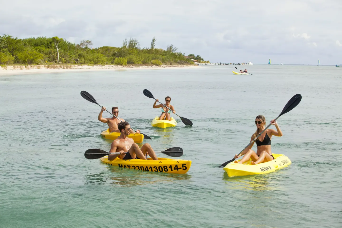 Guests paddling yellow kayaks in calm coastal water at Occidental Cozumel.