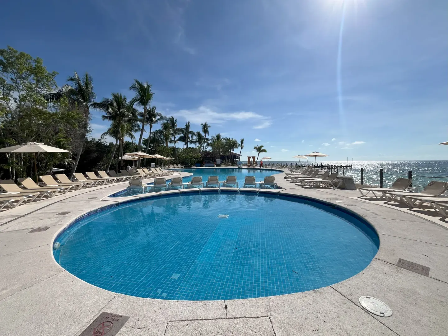 Oceanfront pool with loungers and bright sea views at Occidental Cozumel.