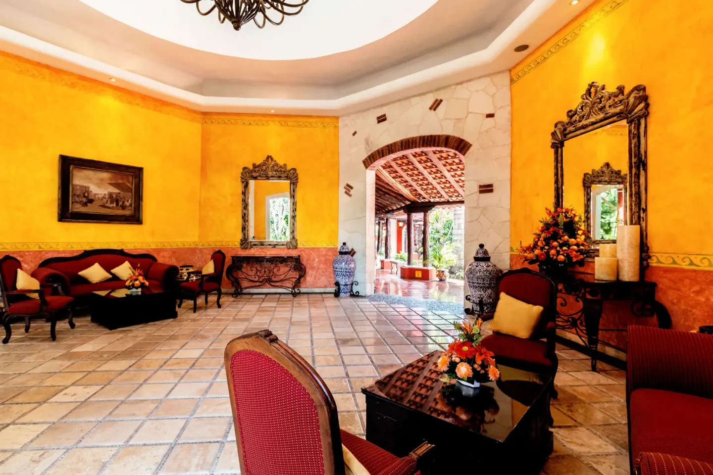 Bright lobby seating area with yellow walls and ornate mirrors at Occidental Cozumel.