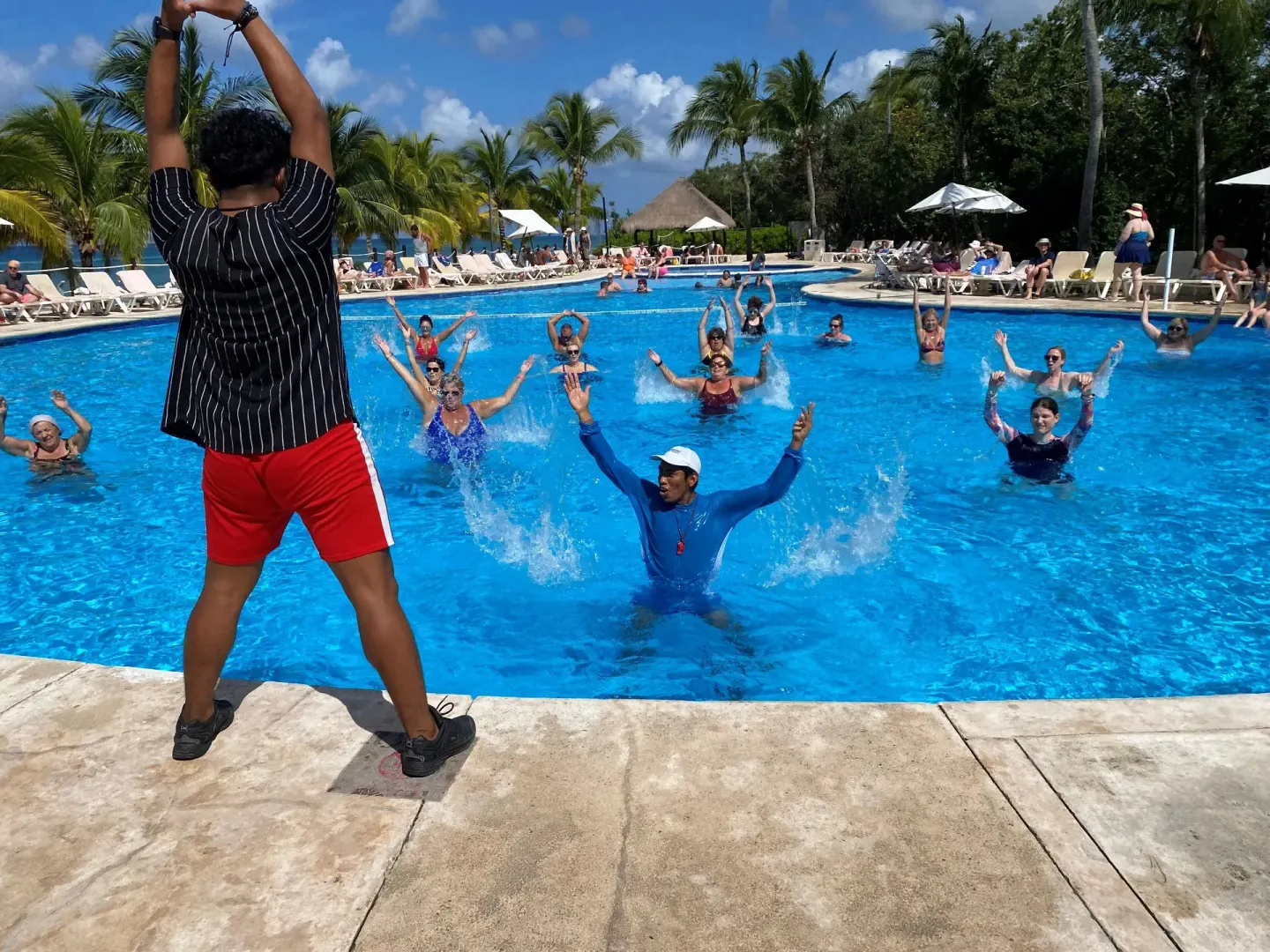 Pool aerobics class with an instructor and guests in the water at Occidental Cozumel.
