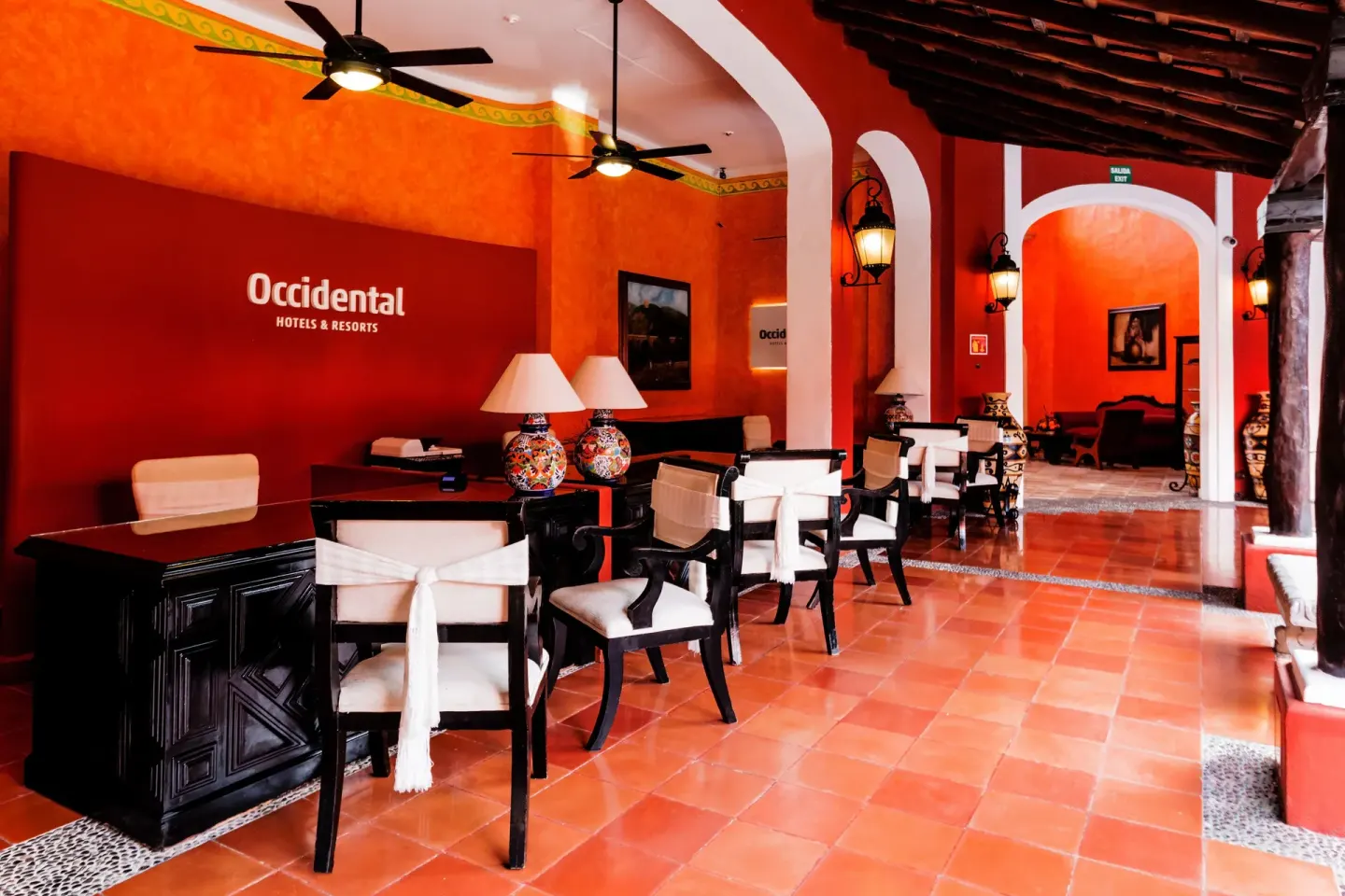 Reception desks and red arched corridor inside the lobby at Occidental Cozumel.