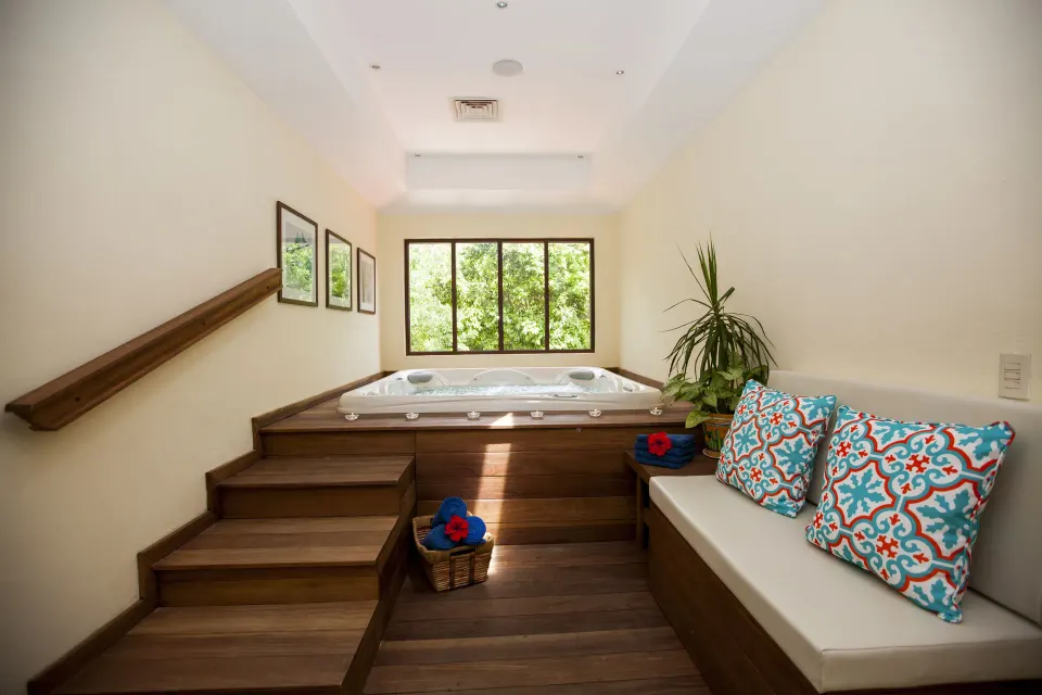 Indoor spa whirlpool with bench seating and colorful pillows at Occidental Cozumel.