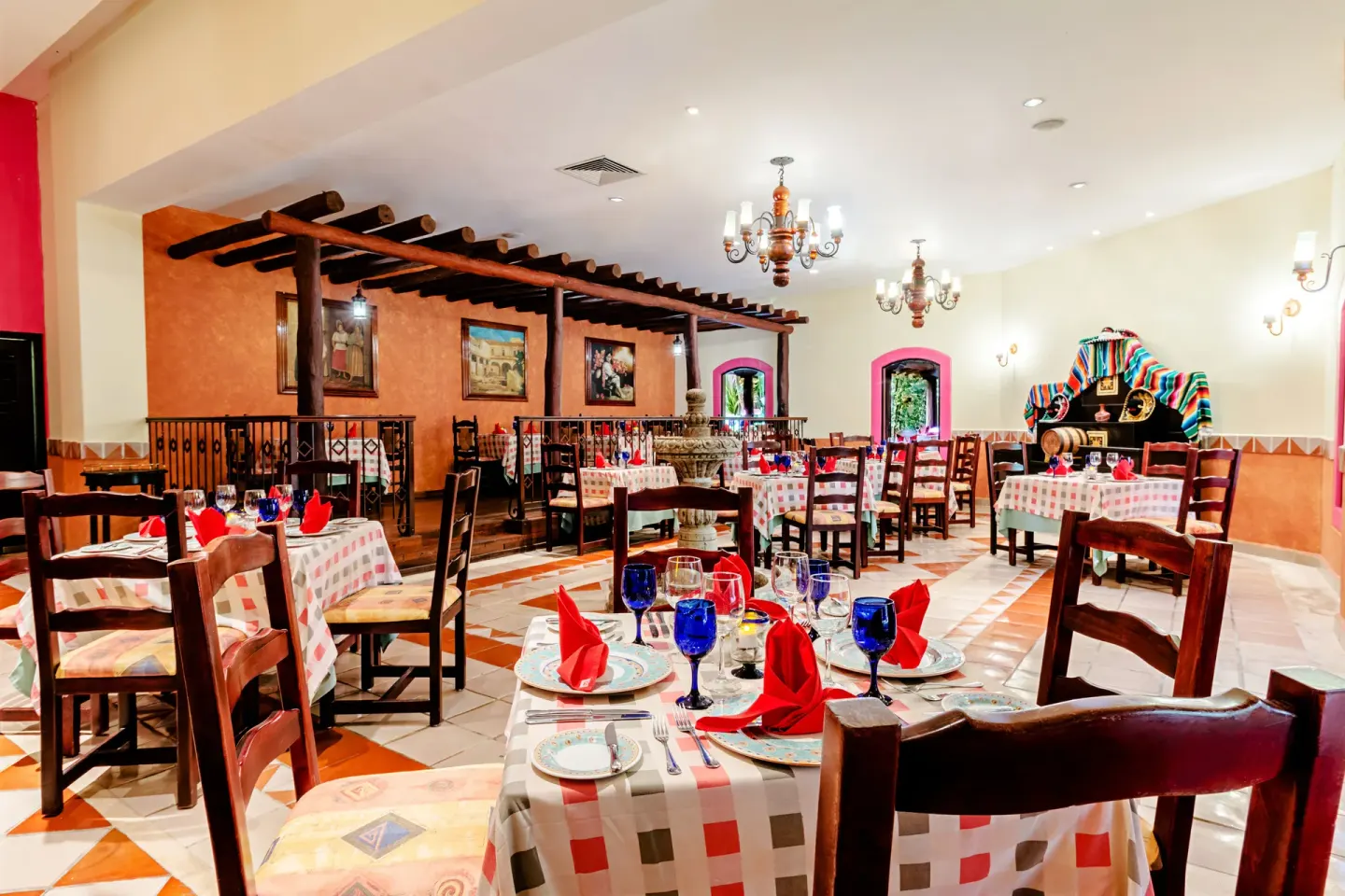 A Mexican-style dining room with red napkins and blue glasses at Occidental Cozumel.