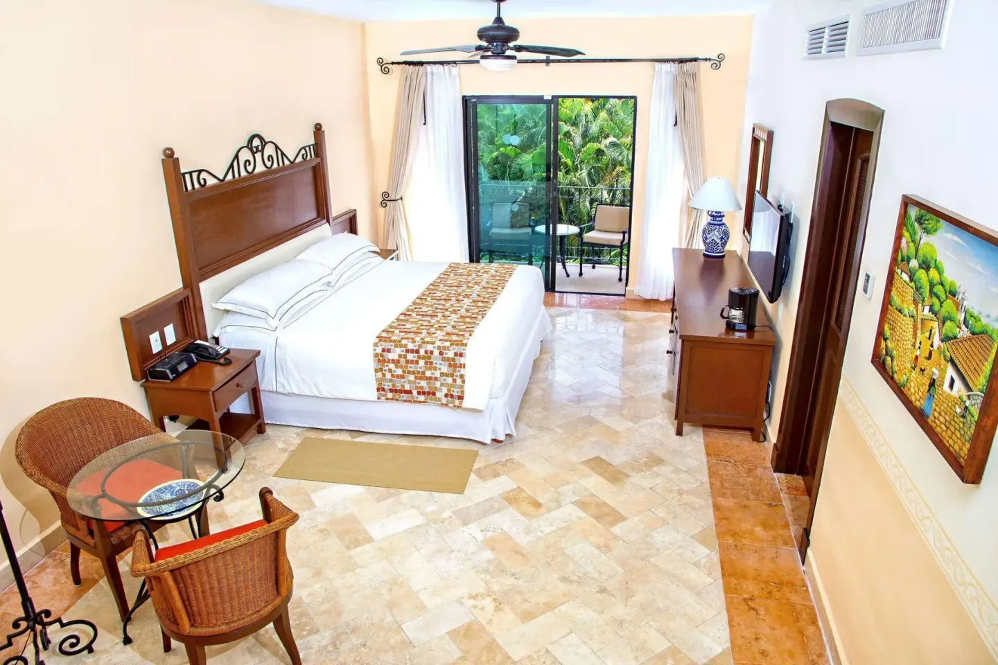 Deluxe Room with king bed, sitting area, and balcony at Occidental Cozumel.