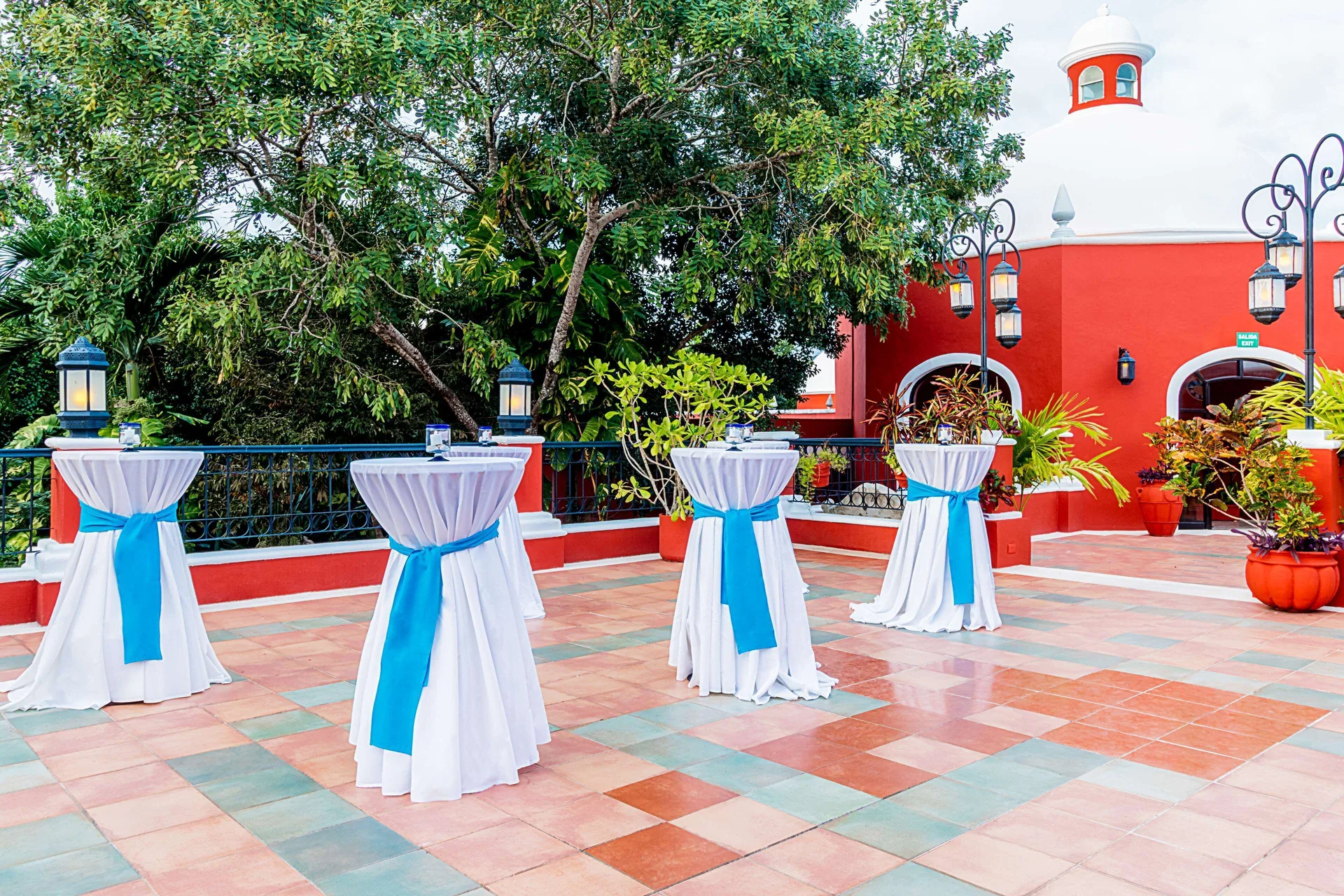 Outdoor terrace with cocktail tables dressed in white and blue at Occidental Cozumel.