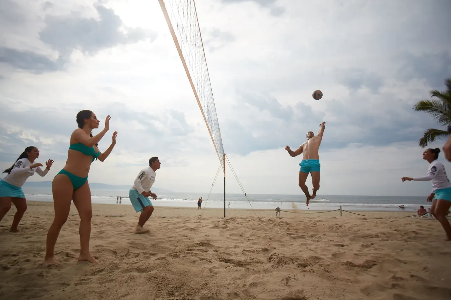 Guests play beach volleyball by the ocean at Occidental Nuevo Vallarta.