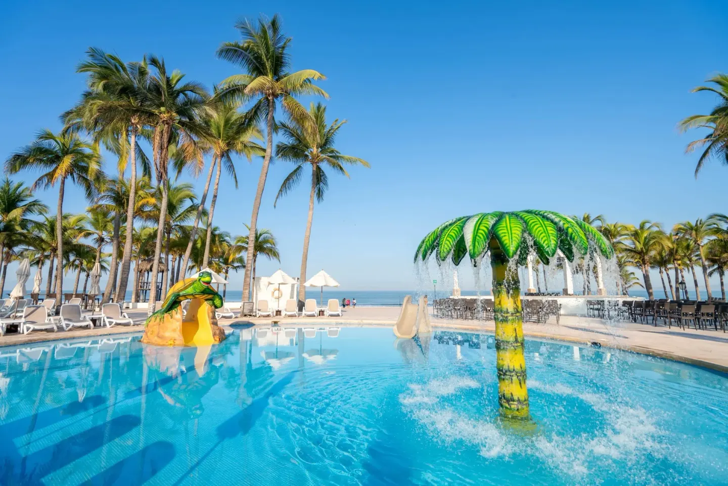 Children’s pool with a palm water feature and frog slide at Occidental Nuevo Vallarta.