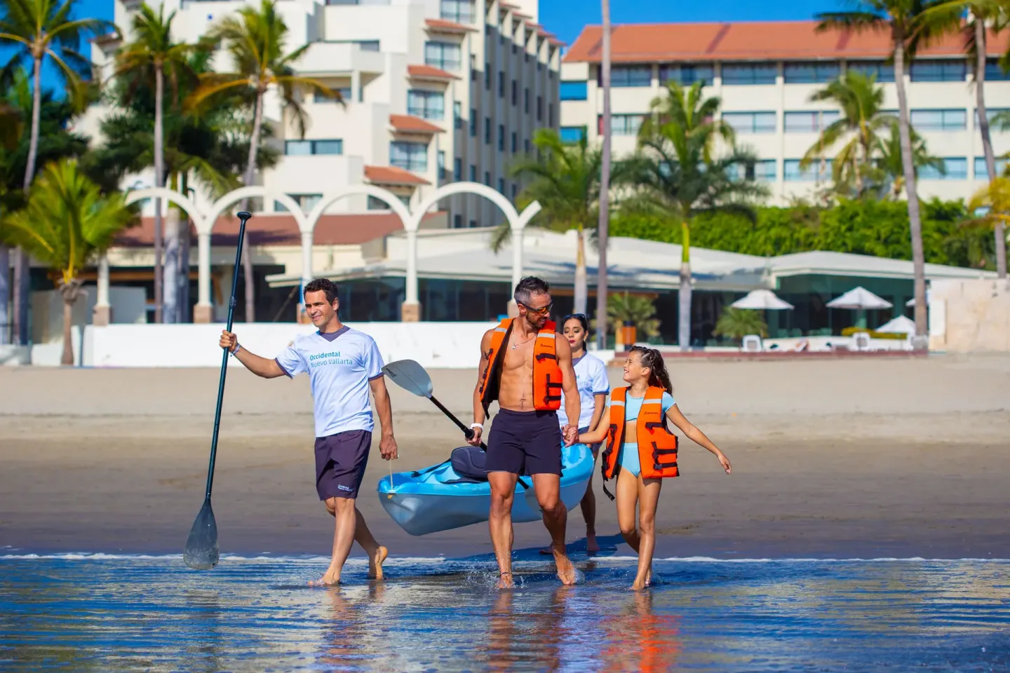 Guests carry a kayak along the shoreline at Occidental Nuevo Vallarta.