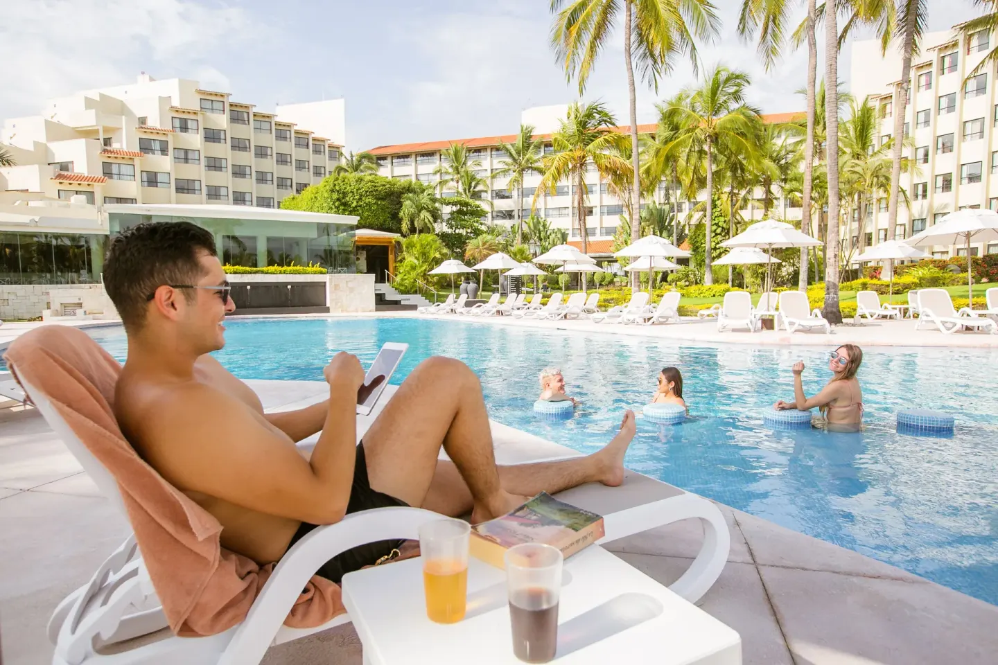 Poolside guest lounging by the water at Occidental Nuevo Vallarta.