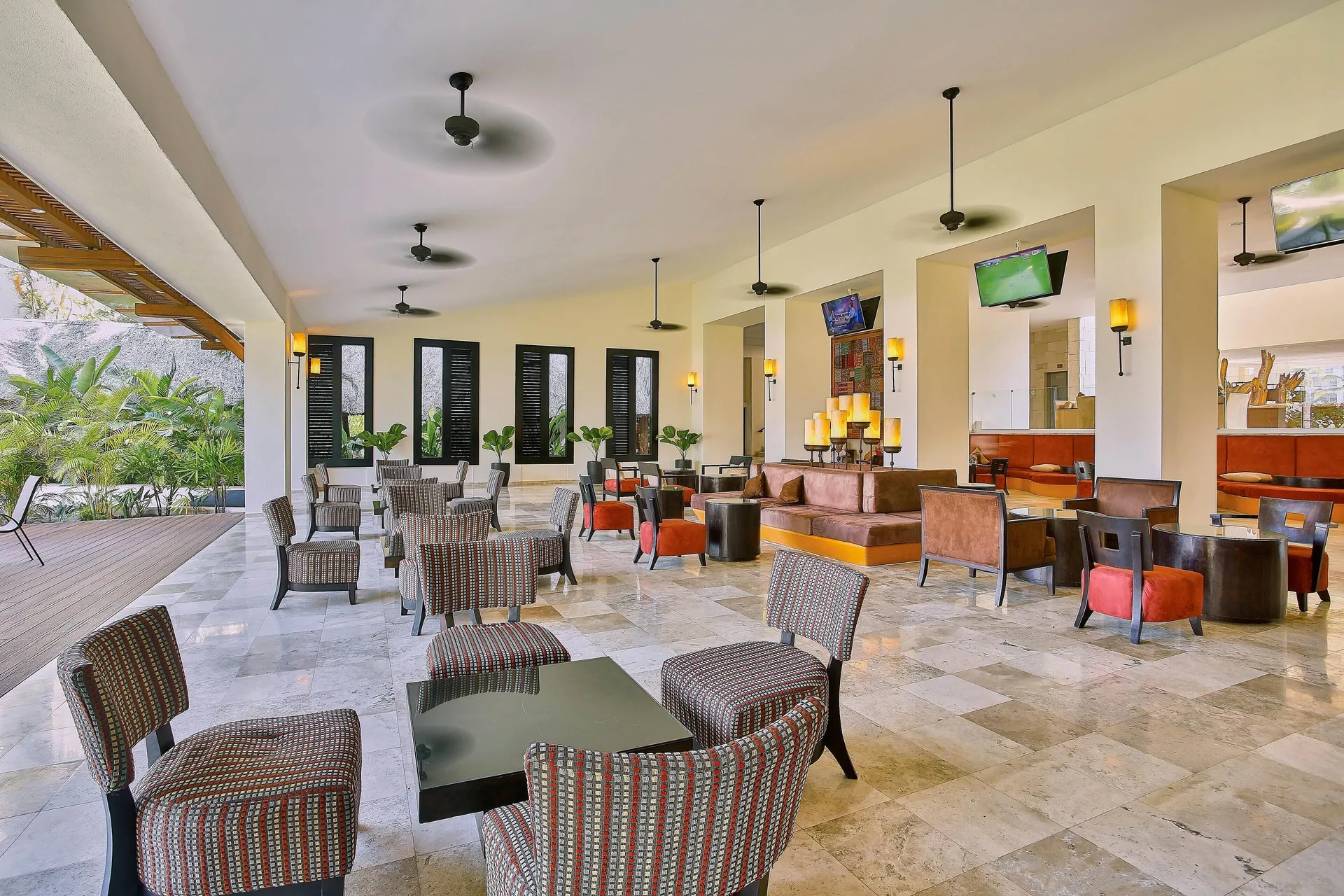 Lounge seating with TVs and garden views at Occidental Nuevo Vallarta.