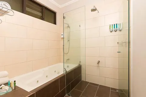 Bathroom with soaking tub and glass shower enclosure at Occidental Papagayo.
