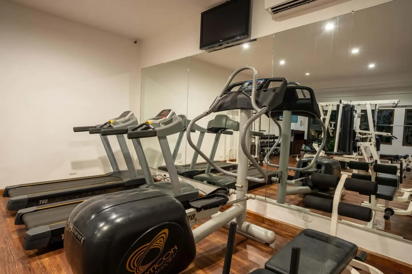 Gym treadmills and exercise machines reflected in mirrors at Occidental Papagayo.