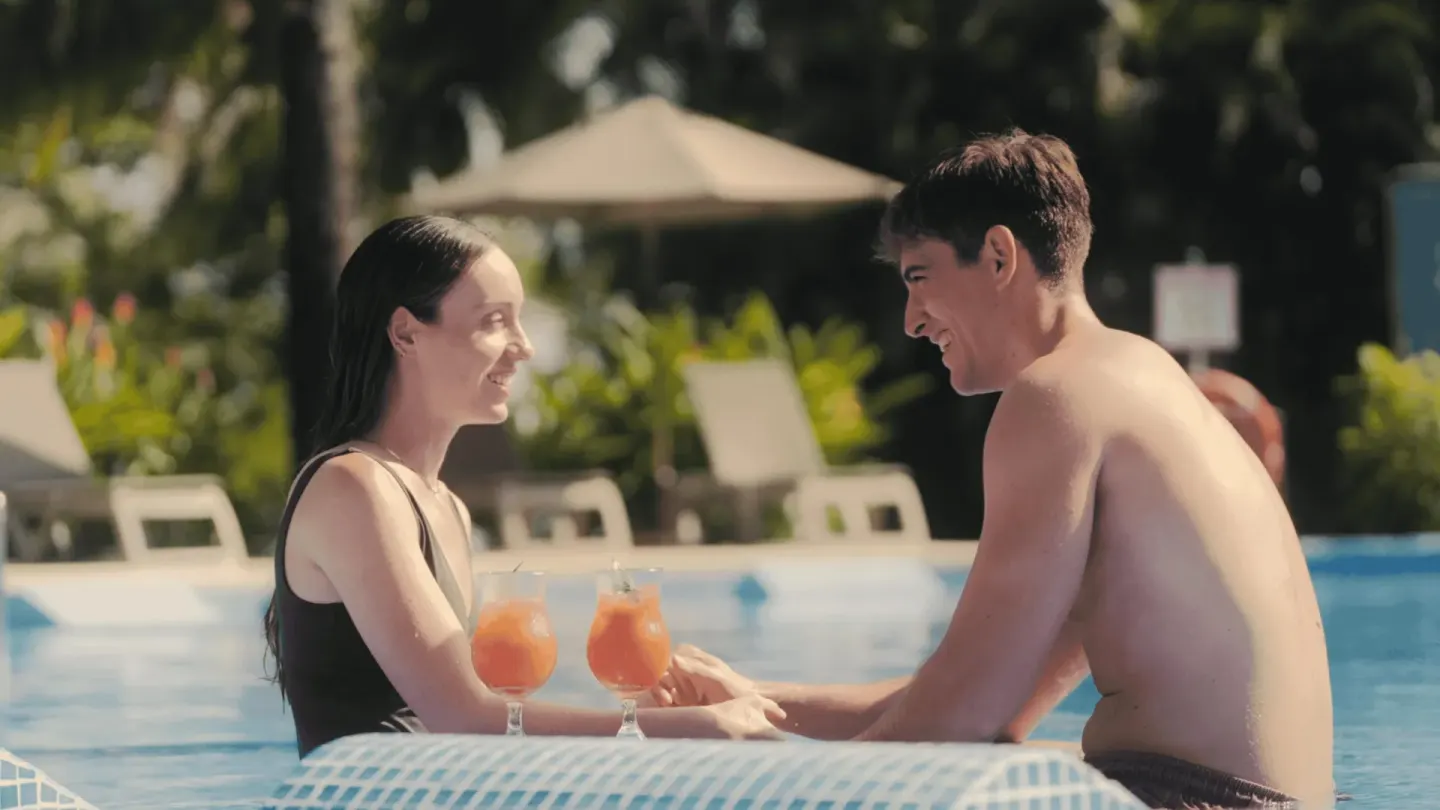 Couple with orange drinks at an in-pool table at Occidental Papagayo.