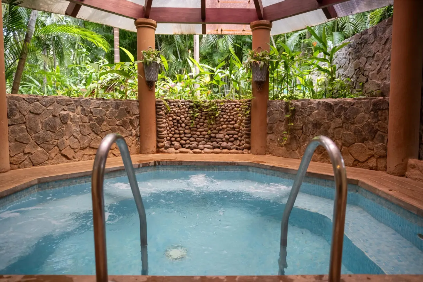 Indoor whirlpool with stone walls and tropical plants at Occidental Papagayo.