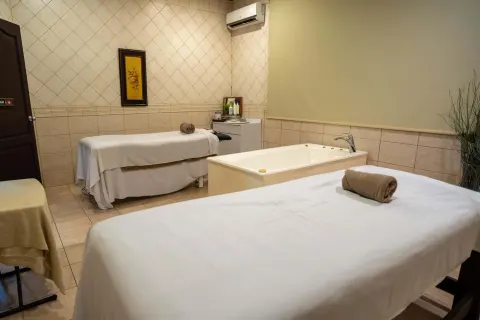 Spa treatment room with massage tables and a soaking tub at Occidental Papagayo.