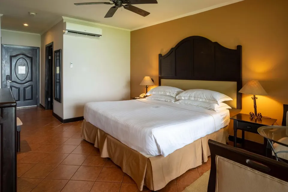 Deluxe Room Bay View king bed and entry area at Occidental Papagayo.