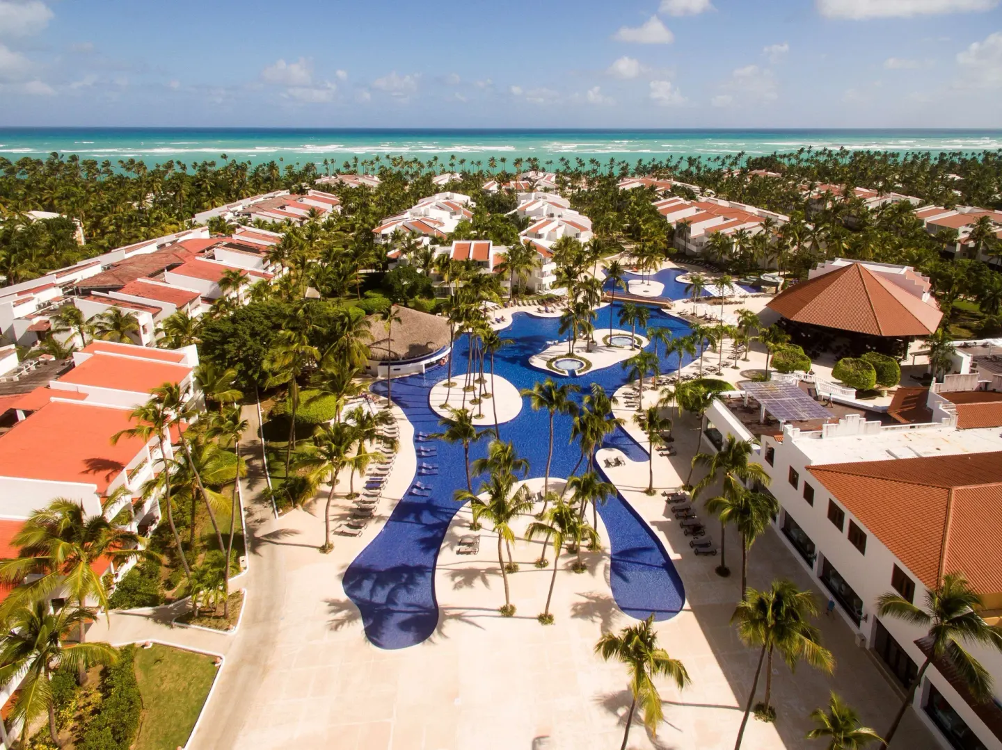High aerial view over the central pool complex and beach at Occidental Punta Cana.