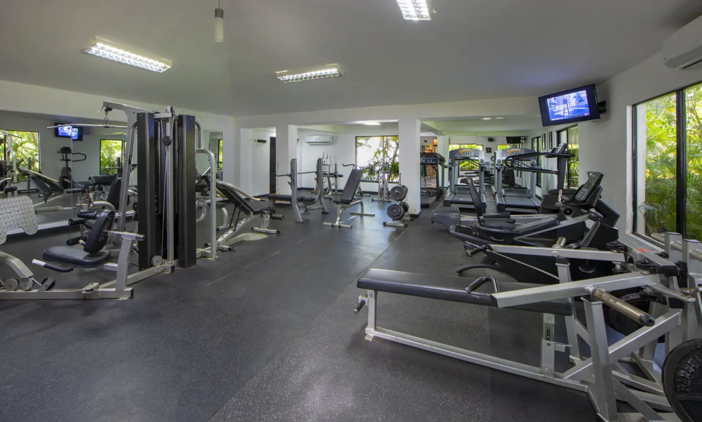 Fitness center with treadmills, weight machines, and mirrors at Occidental Punta Cana.