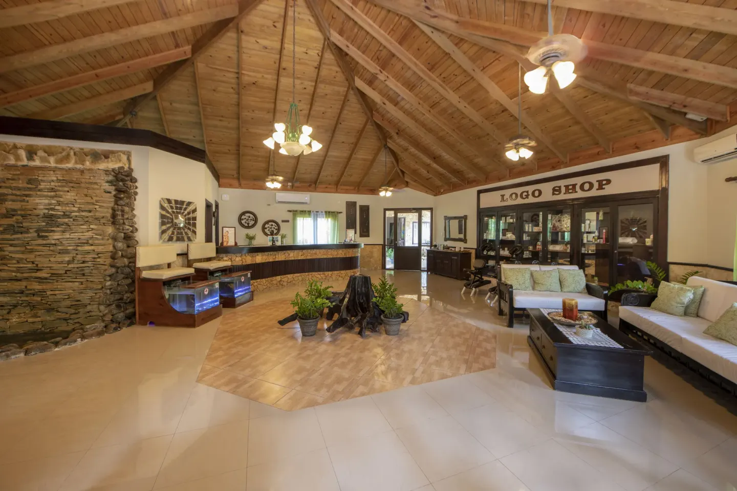 Spa reception lounge with seating, displays, and wood ceiling at Occidental Punta Cana.