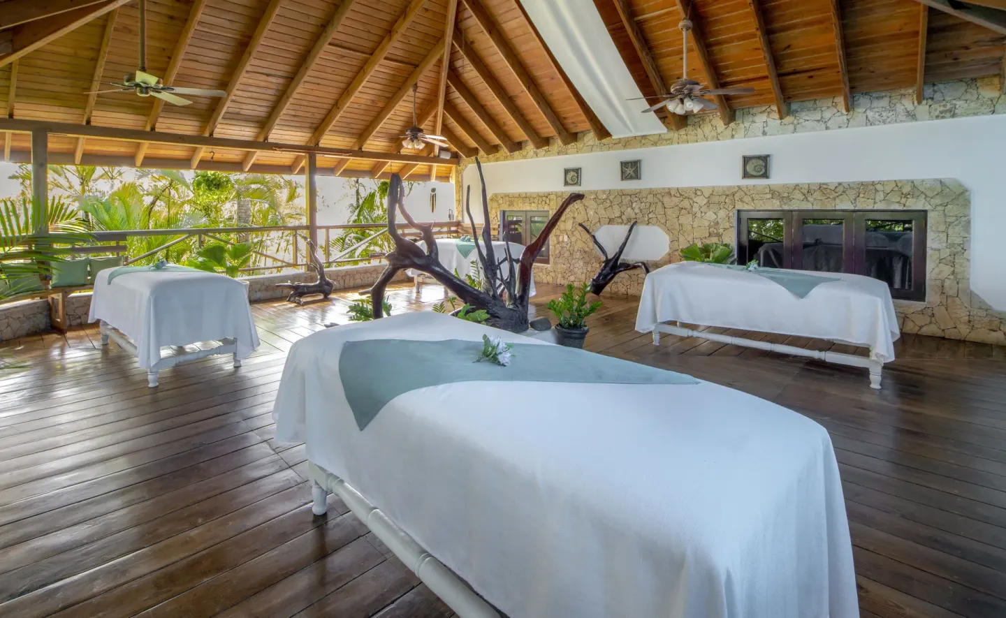 Open spa treatment area with massage tables and wood ceiling at Occidental Punta Cana.