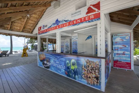 Watersport and dive center counter with activity posters at Occidental Punta Cana.