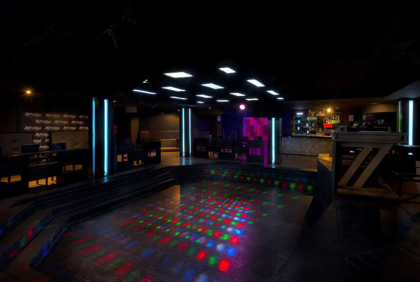 Nightclub dance floor with colored lights and bar at Occidental Punta Cana.