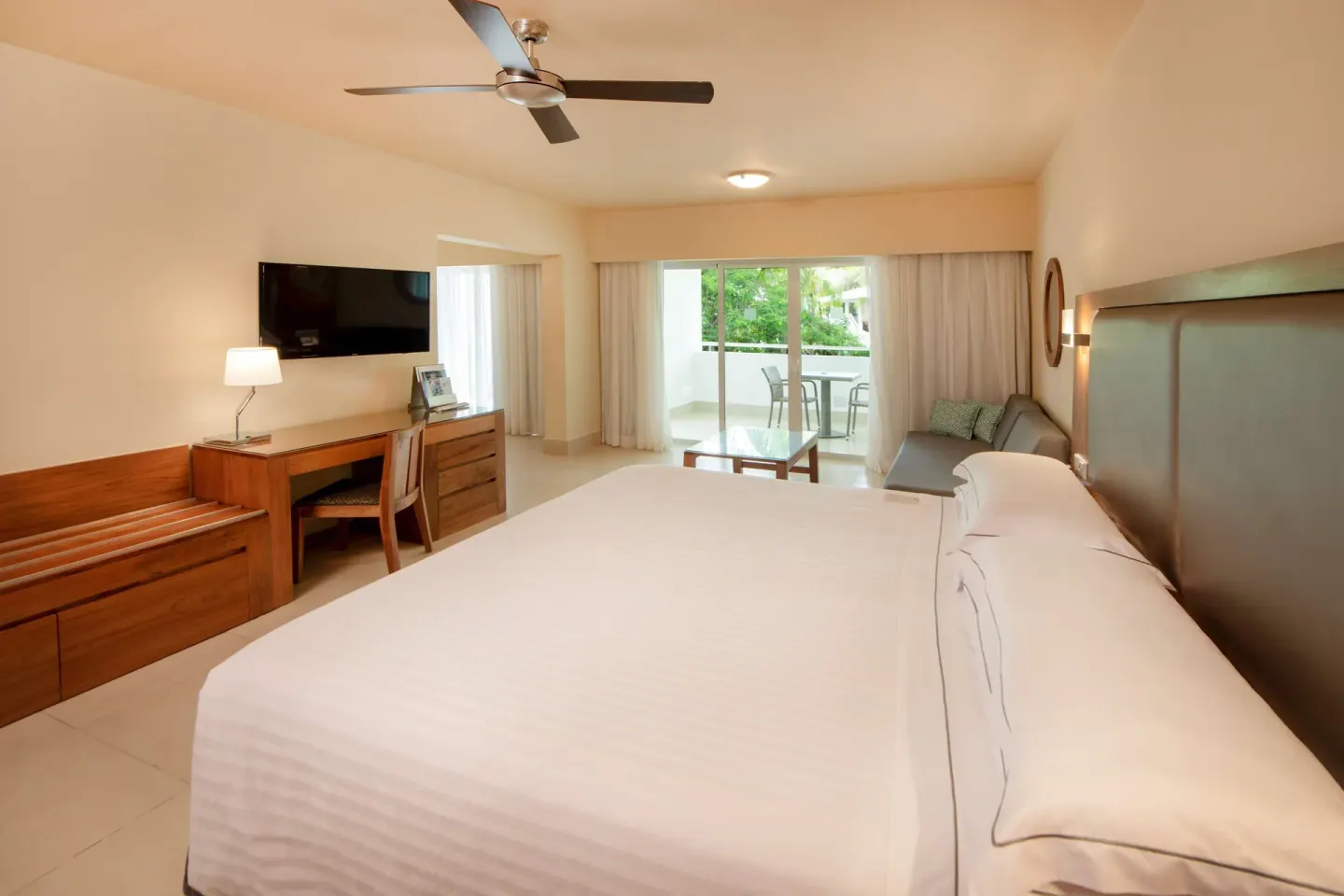 Family Junior Suite king bed, sitting area and balcony at Occidental Punta Cana.
