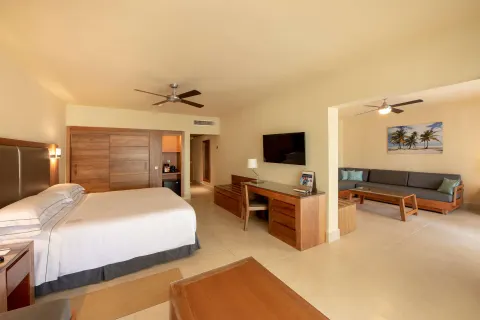 Family Junior Suite king bed, desk and separate lounge at Occidental Punta Cana.