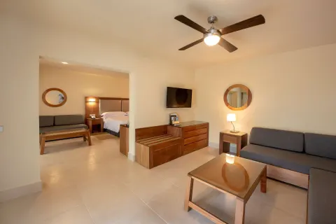 Family Junior Suite living area with sofa and bedroom beyond at Occidental Punta Cana.