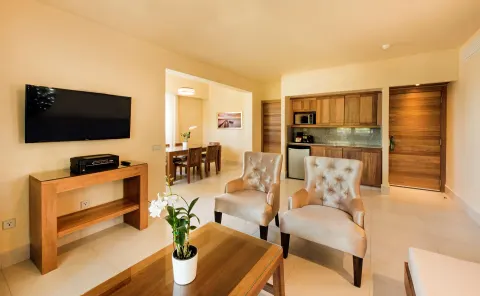 Royal Level Suite living area with chairs and kitchenette at Occidental Punta Cana.