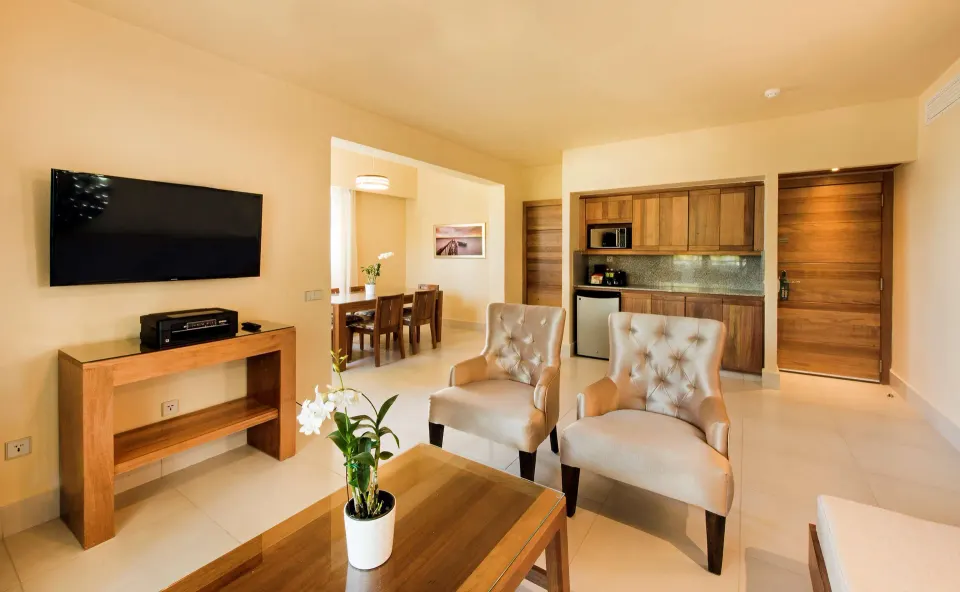 Royal Level Suite living area with chairs and kitchenette at Occidental Punta Cana.