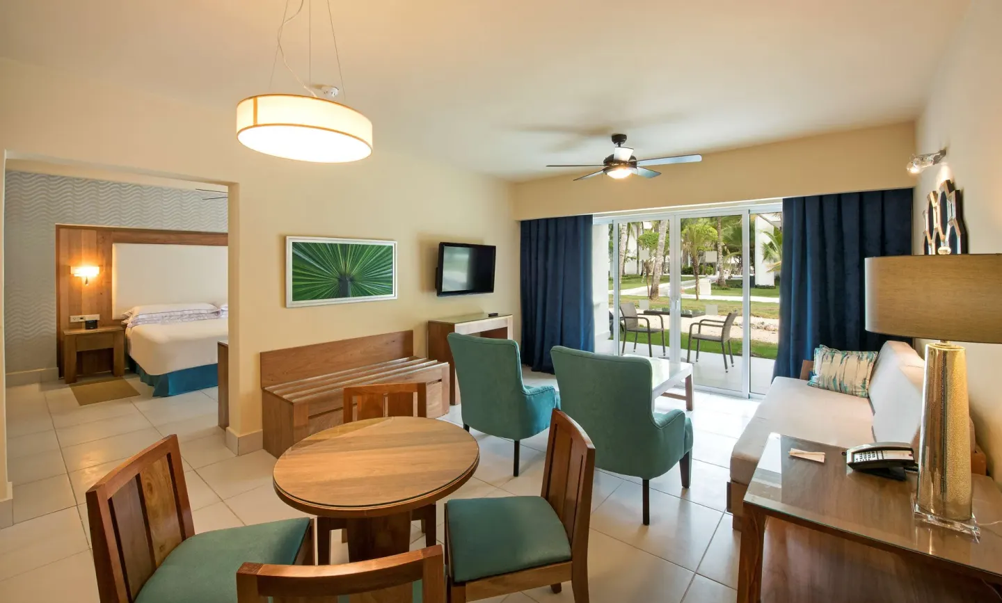 Suite living area with dining table, seating, and bedroom at Occidental Punta Cana.
