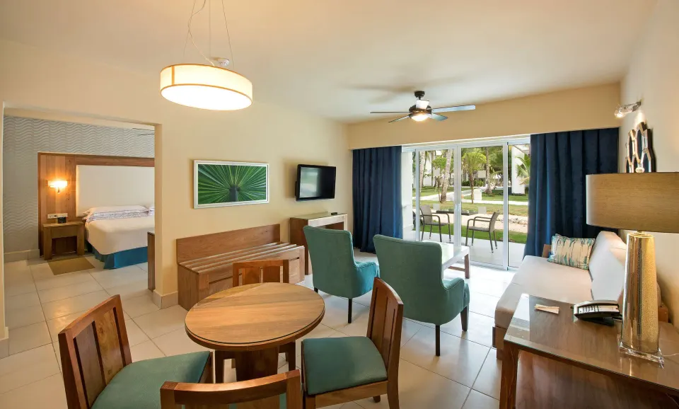 Suite living area with dining table, seating, and bedroom at Occidental Punta Cana.
