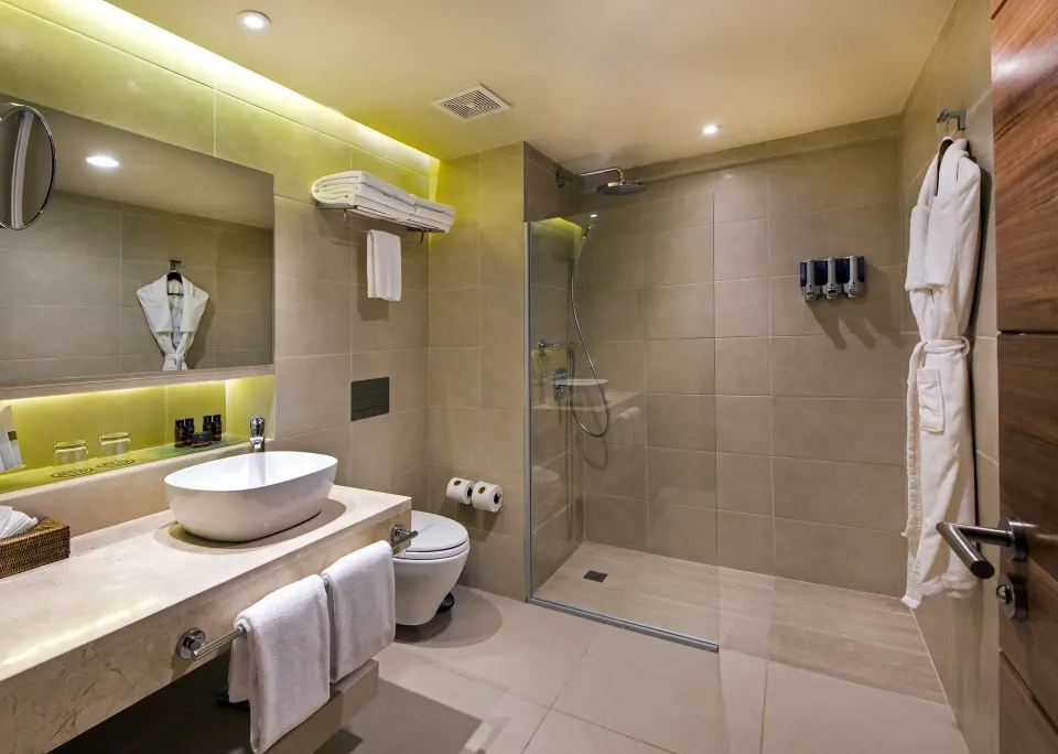 Royal Level Superior Room bathroom with vessel sink and glass shower at Occidental Punta Cana.